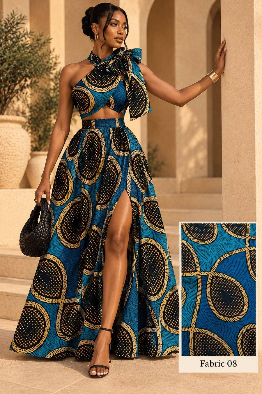 Model in a teal and gold circle-print one-shoulder bow top and split maxi skirt among sandstone arches